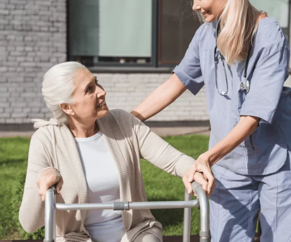 6- Lady healthcare worker guiding elderly woman on a walk