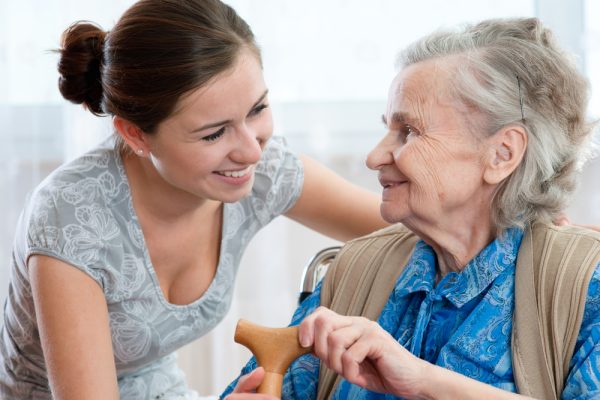 Older woman and caregiver sharing a laugh.