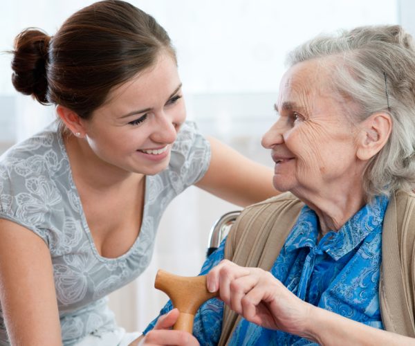 Older woman and caregiver sharing a laugh.